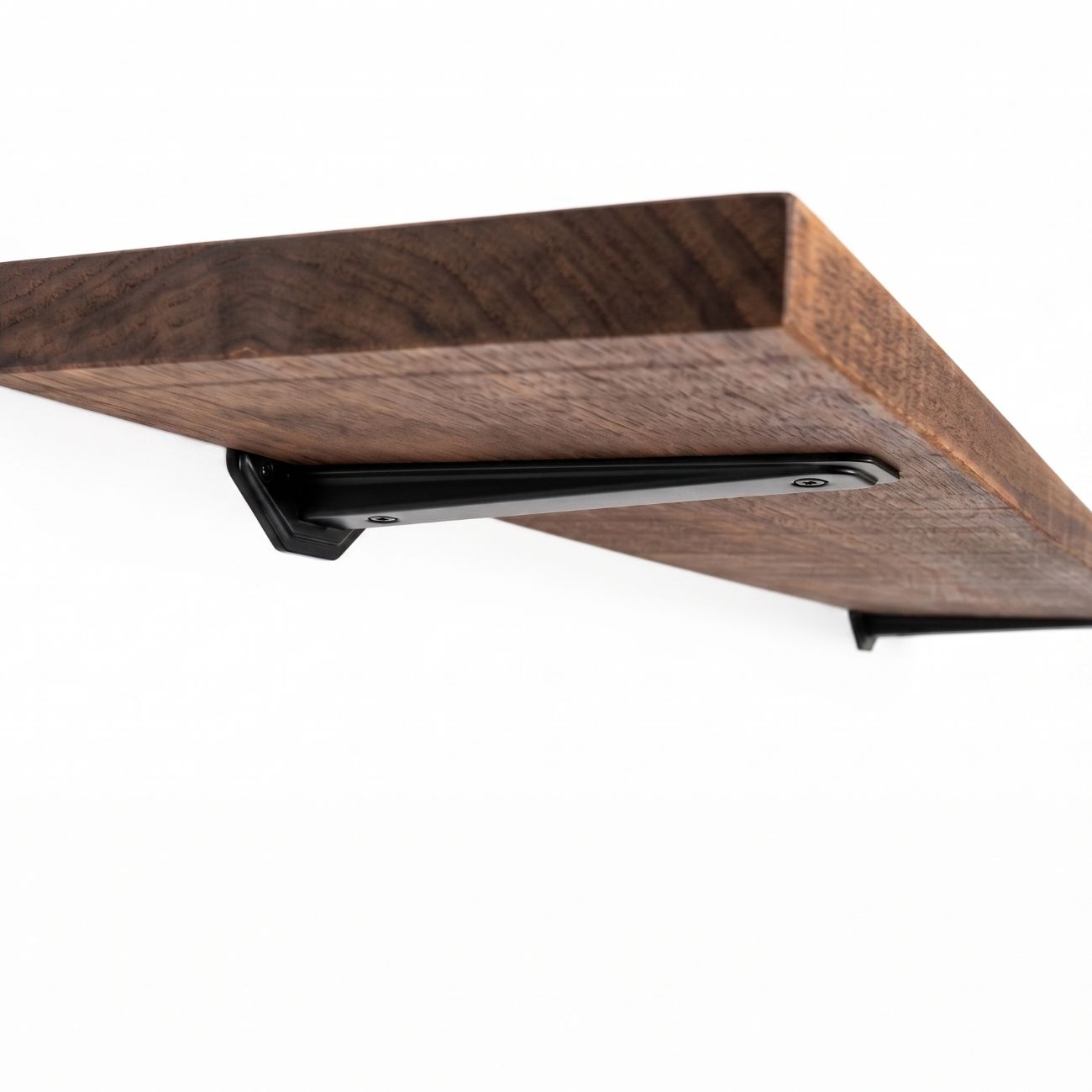 wooden shelf showing black brackets in a white background