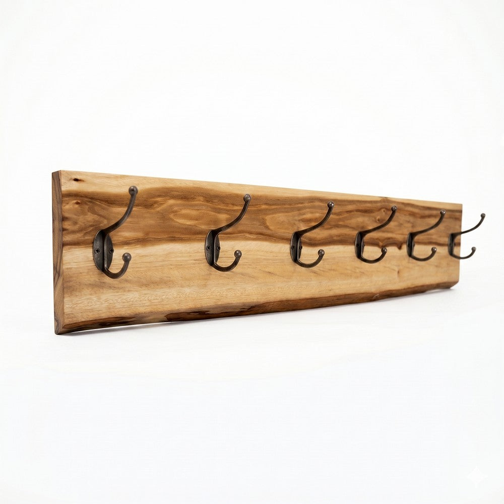 A clean product shot of a live-edge camphor laurel wood coat rack with six antique-style black double hooks, isolated at an angle against a seamless, solid white background to showcase the natural wood grain.