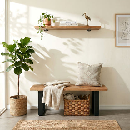 Nest living room with wooden bench, plant, shelf, and decor items.