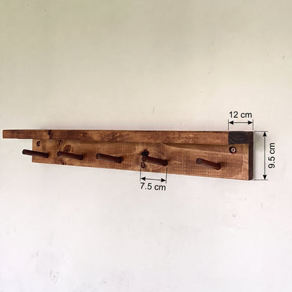 A rustic wooden wall-mounted coat rack with five hooks, shown against a plain off-white wall with dimension annotations indicating 9.5 cm height, 12 cm hook width, and 7.